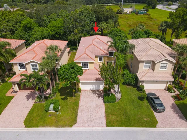 an aerial view of a house with a garden and lake view