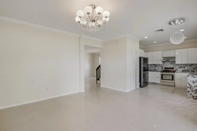 a kitchen with stainless steel appliances granite countertop a refrigerator stove oven and sink