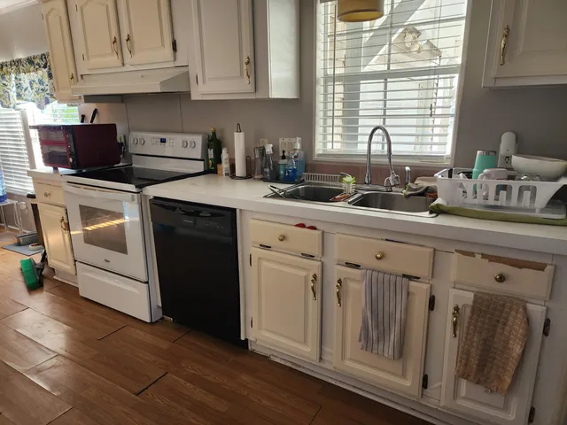 a kitchen with white cabinets and sink