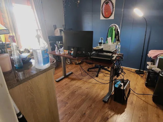 a view of a workspace with furniture and a window