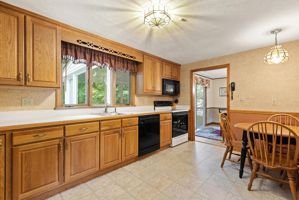 1 Robbin Road Canton, MA 02021 - Photo 25 of 40 a open kitchen with stainless steel appliances granite countertop a stove top oven a sink a dining table and chairs with wooden floor