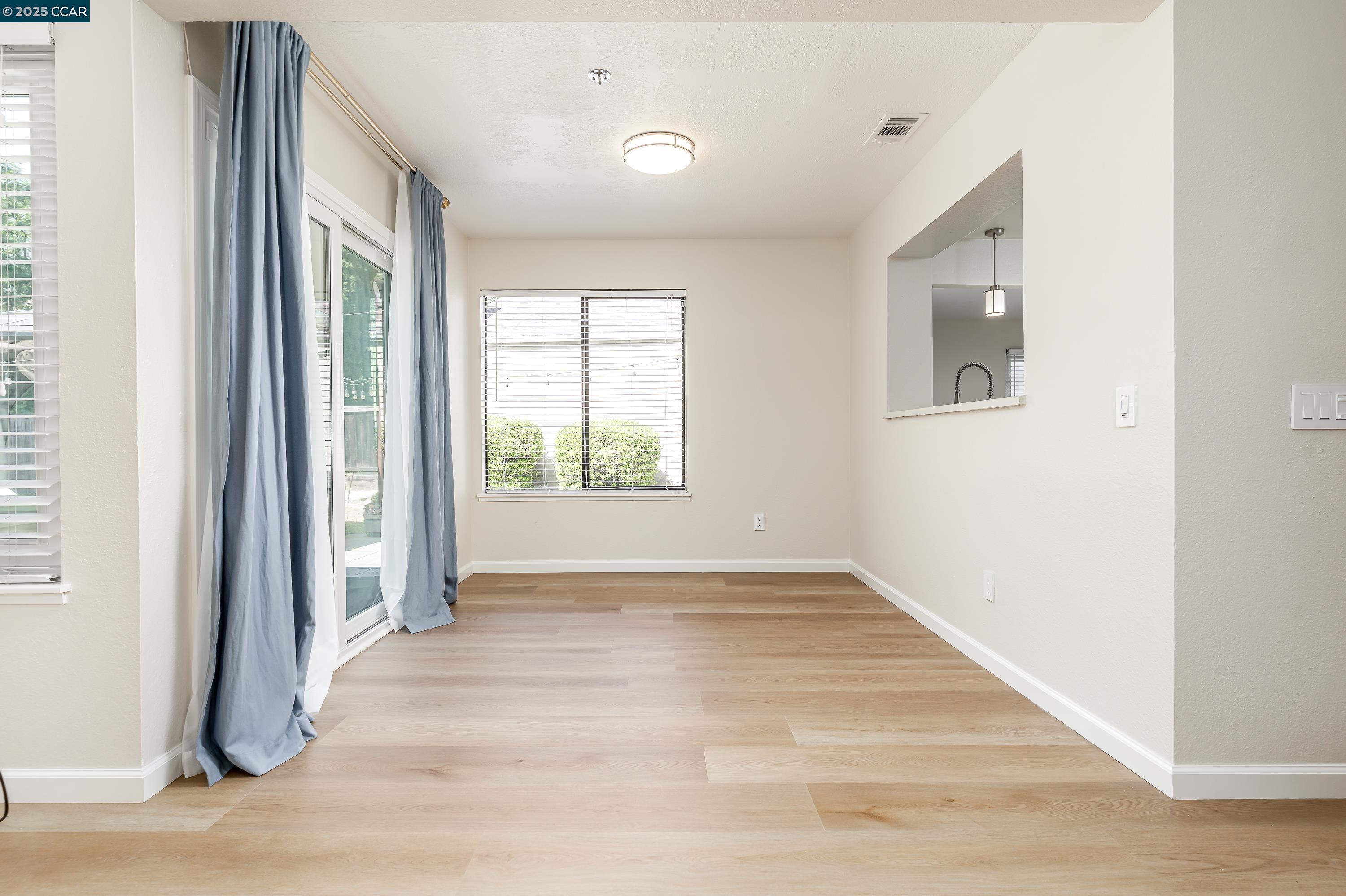 121 Brighton Street Hercules, CA 94547 - Photo 12 of 55 a view of an empty room with wooden floor and a window