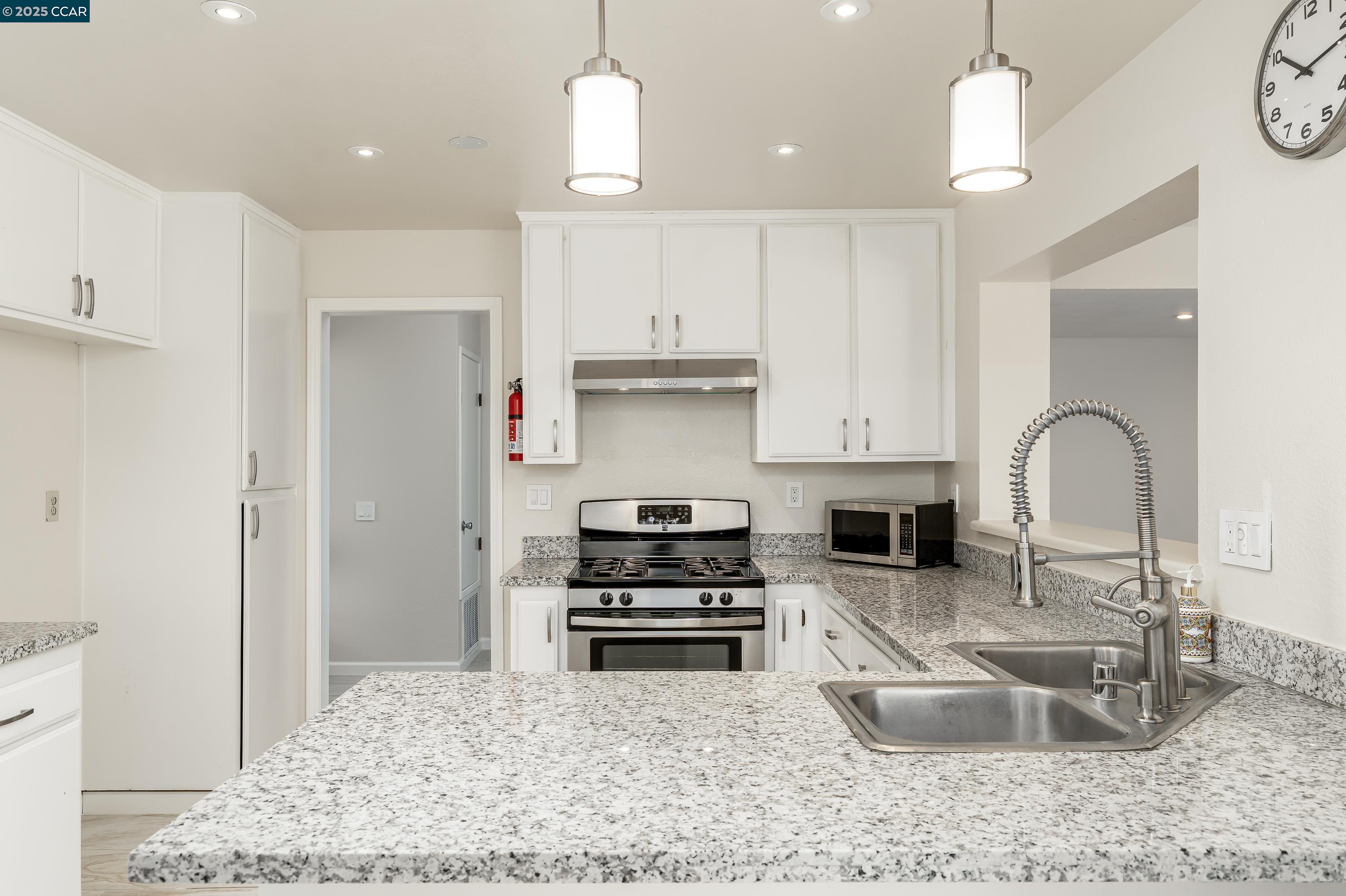 121 Brighton Street Hercules, CA 94547 - Photo 13 of 55 a kitchen with granite countertop a stove a sink and a refrigerator