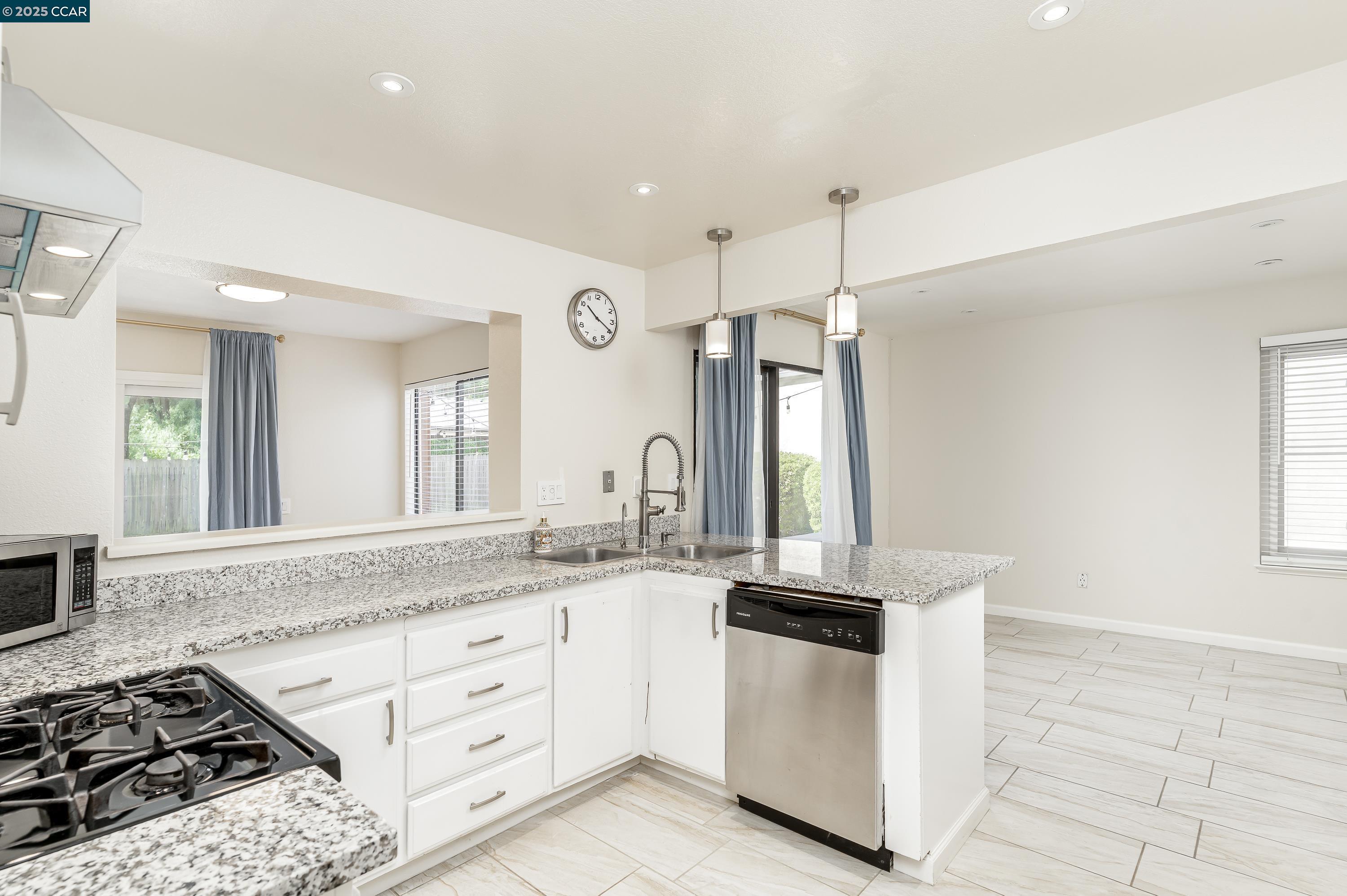 121 Brighton Street Hercules, CA 94547 - Photo 18 of 55 a kitchen with granite countertop a sink stainless steel appliances a window and a counter top space