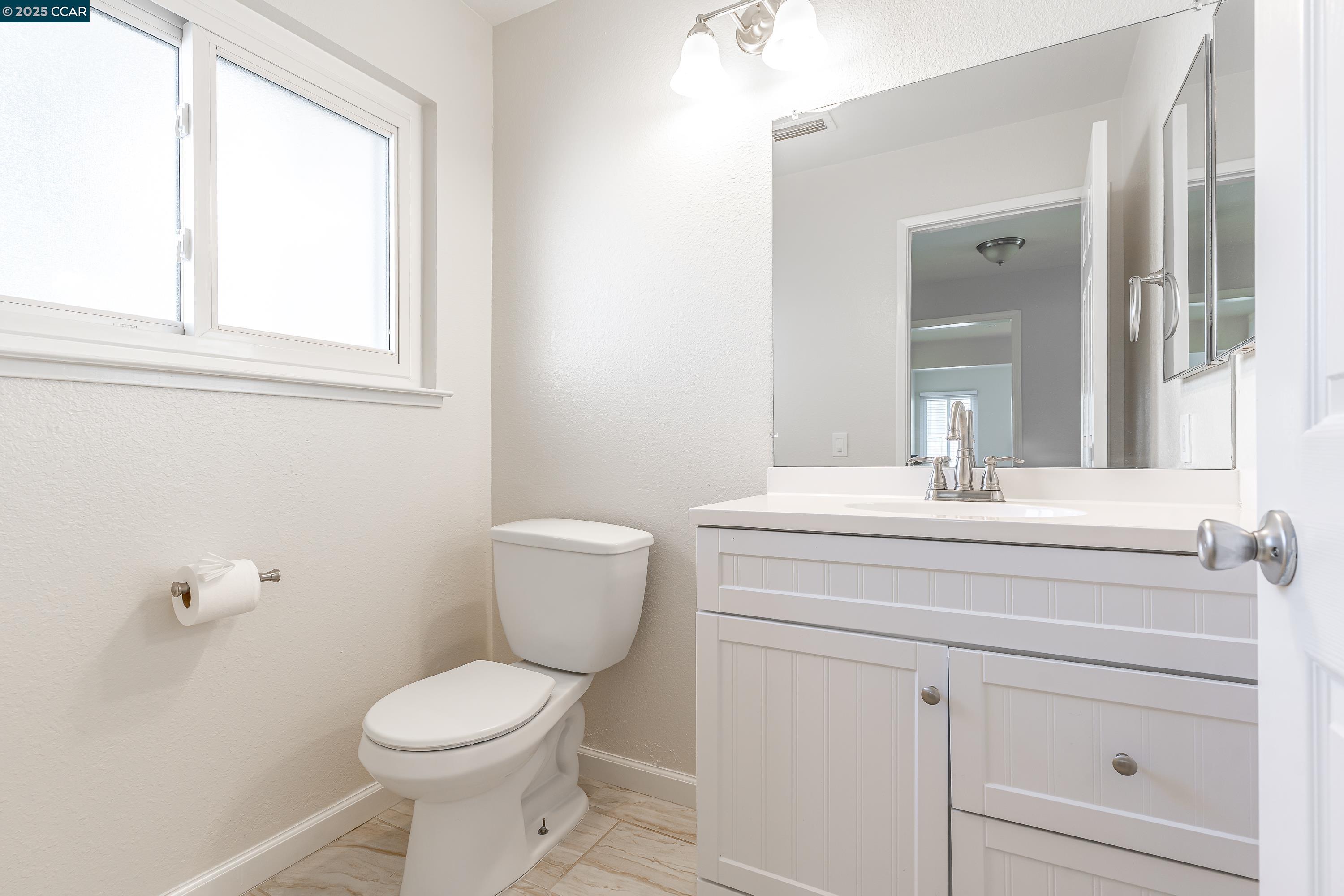 121 Brighton Street Hercules, CA 94547 - Photo 40 of 55 a bathroom with a toilet sink and mirror