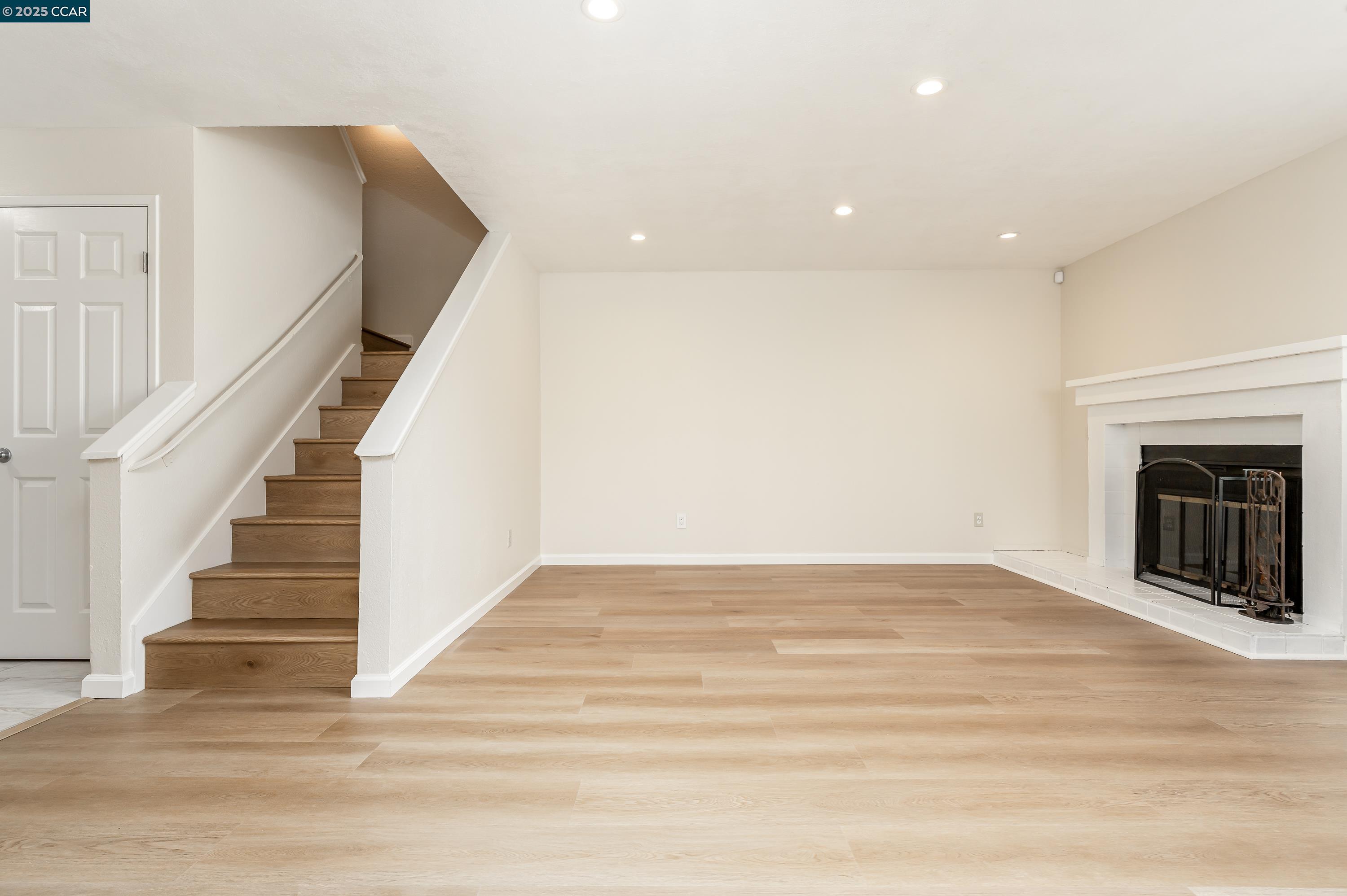 121 Brighton Street Hercules, CA 94547 - Photo 4 of 55 a view of an empty room with wooden floor and a fireplace