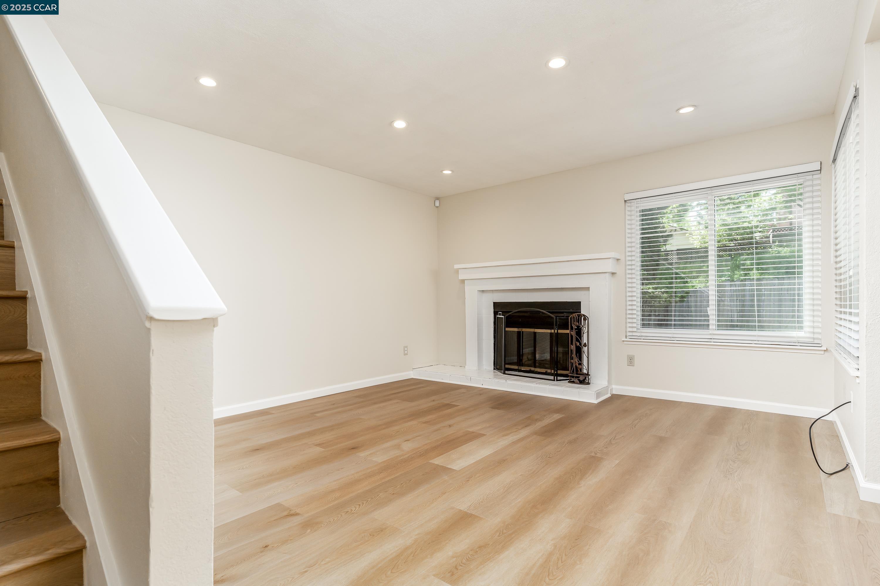 121 Brighton Street Hercules, CA 94547 - Photo 5 of 55 a view of an empty room with a fireplace and a window