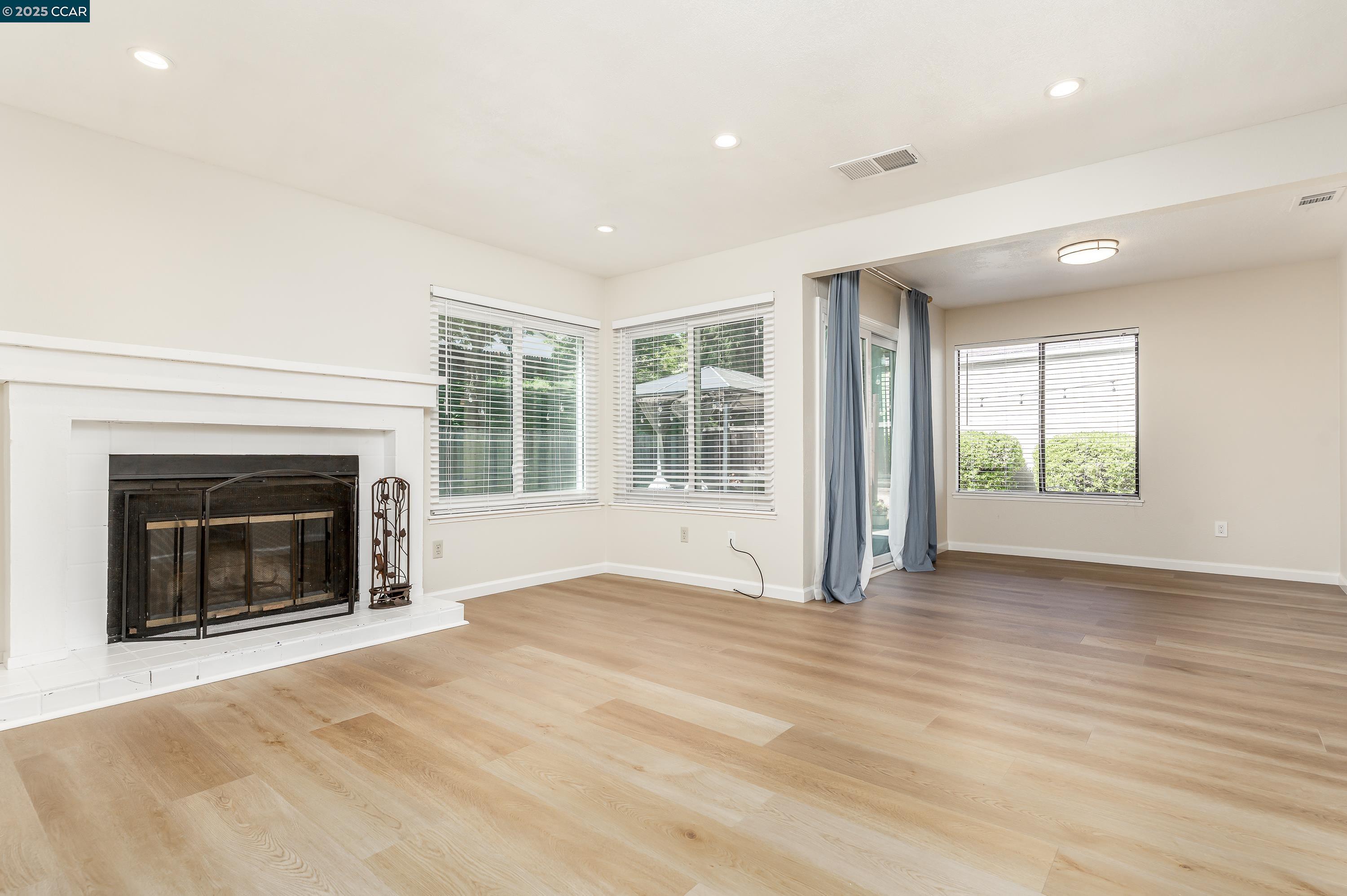 121 Brighton Street Hercules, CA 94547 - Photo 8 of 55 a view of an empty room with wooden floor fireplace and a window