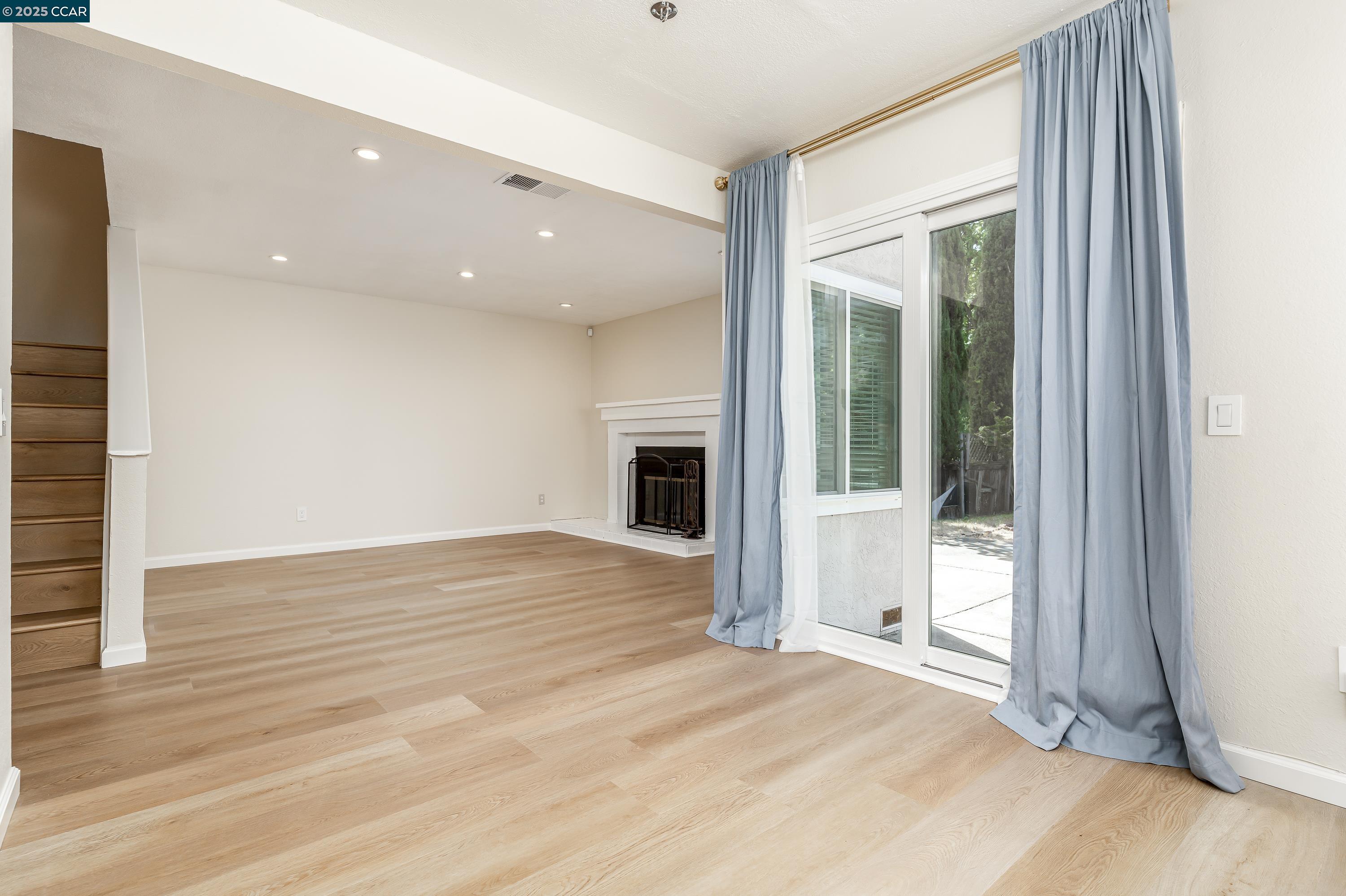 121 Brighton Street Hercules, CA 94547 - Photo 10 of 55 a view of an empty room with wooden floor and a window