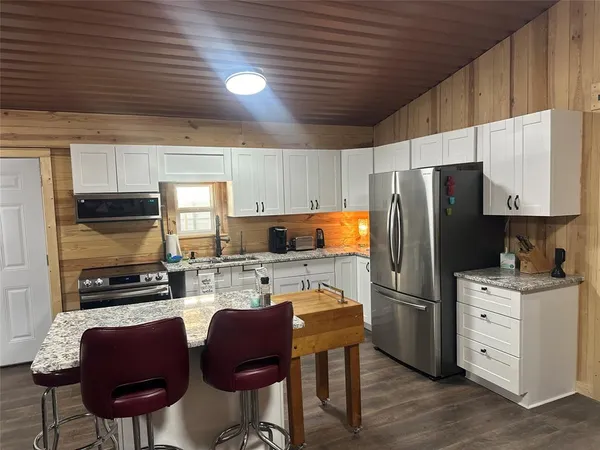 a kitchen with stainless steel appliances granite countertop a stove a sink and a microwave