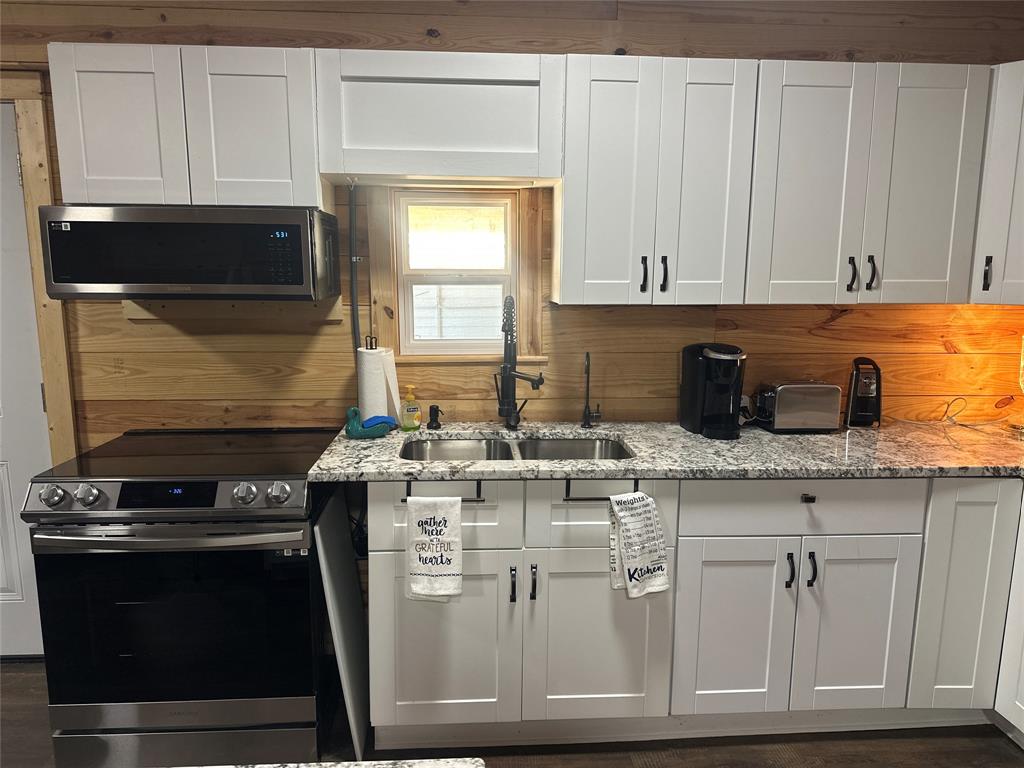 191 Cherry Lane Streetman, TX 75859 - Photo 10 of 40 a kitchen with stainless steel appliances granite countertop a stove a sink and a microwave