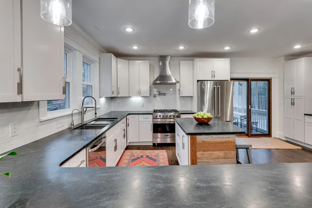 a kitchen with stainless steel appliances granite countertop a refrigerator a sink and a stove