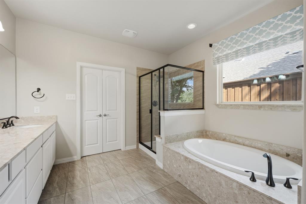 12809 Spring Hill Drive Frisco, TX 75035 - Photo 27 of 37 a spacious bathroom with a tub sink and mirror