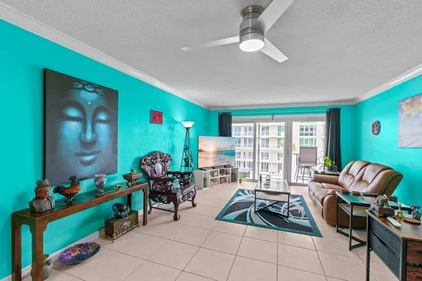 a living room with furniture a flat screen tv and a large window