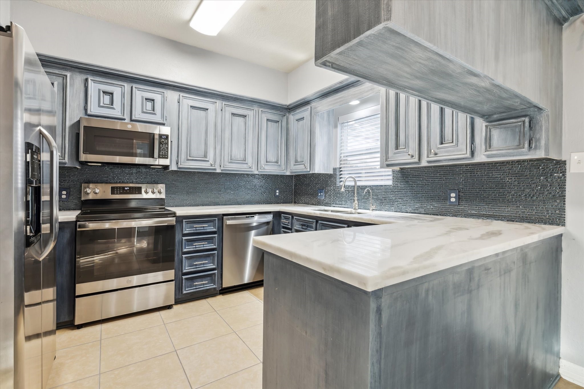 7671 Ameswood Road Houston, TX 77095 - Photo 7 of 23 The kitchen has abundant marble countertops and wood cabinetry which is nicely updated with custom paint in 2022.