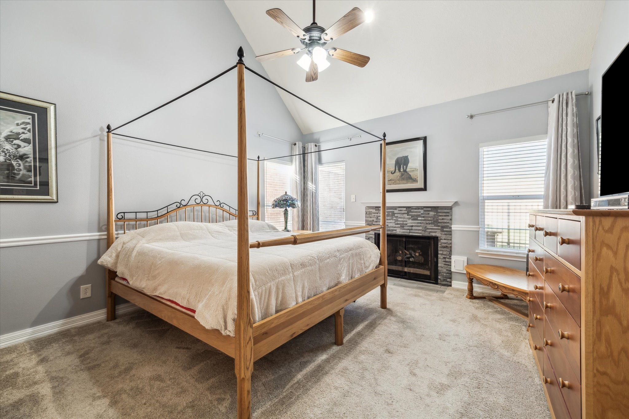 7671 Ameswood Road Houston, TX 77095 - Photo 10 of 23 The primary suite captures abundant natural light from three windows which flank the gas log fireplace with stone facade. The primary suite has two large walk in closets plus abundant cabinetry in the ensuite bathroom.