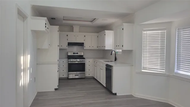 a kitchen with stainless steel appliances granite countertop a stove a sink and a refrigerator