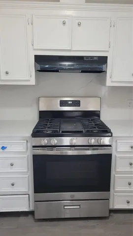 a stove top oven sitting inside of a kitchen