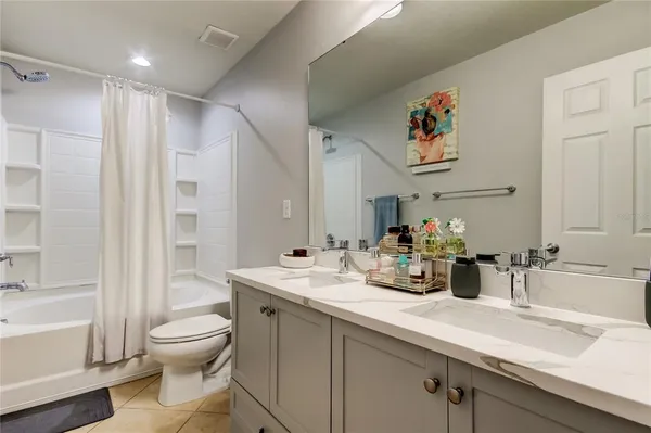 a bathroom with a granite countertop sink a toilet and a mirror