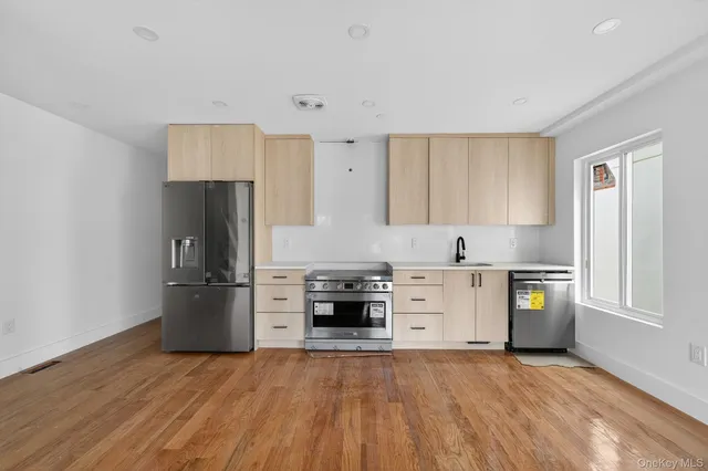 a kitchen with stainless steel appliances a refrigerator sink and stove