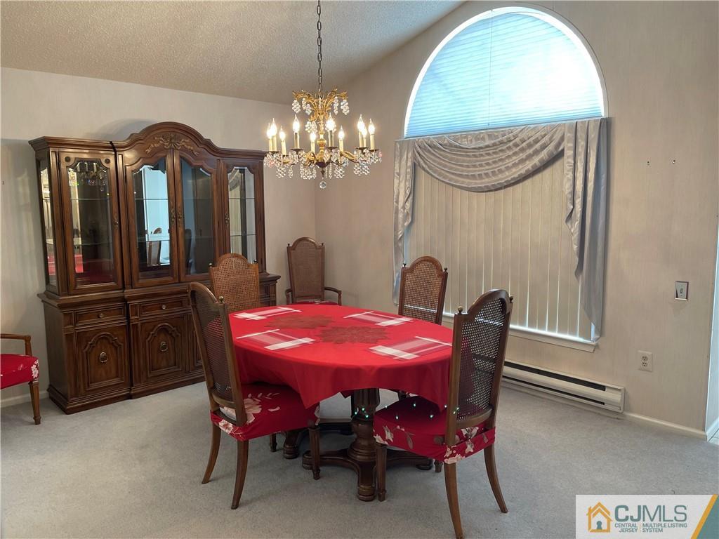 656 Nutley Drive, Unit A Monroe Township, NJ 08831 - Photo 15 of 25 a view of a dining room with furniture and chandelier