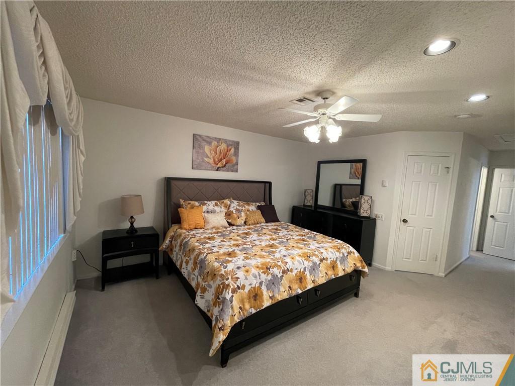 656 Nutley Drive, Unit A Monroe Township, NJ 08831 - Photo 18 of 25 a bedroom with a bed and a chandelier