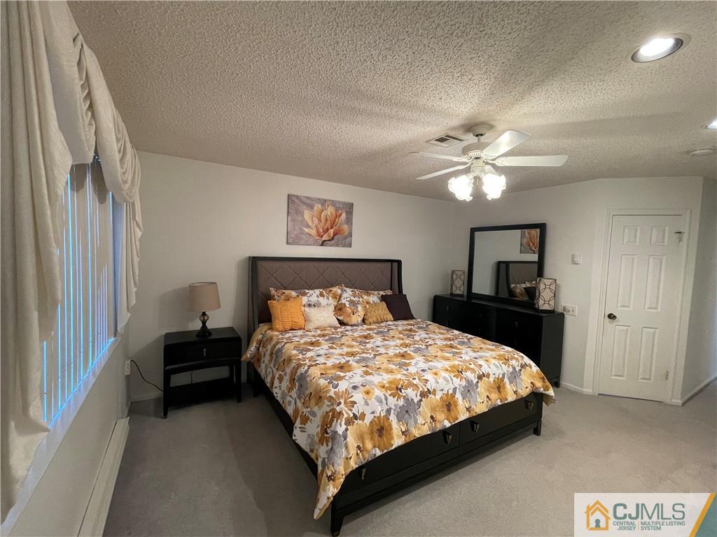 656 Nutley Drive, Unit A Monroe Township, NJ 08831 - Photo 19 of 25 a bedroom with a bed and a chandelier