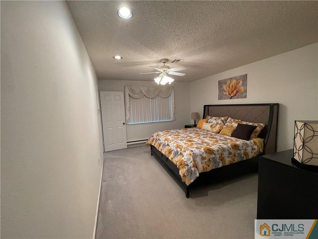 656 Nutley Drive, Unit A Monroe Township, NJ 08831 - Photo 20 of 25 a bed sitting in a bedroom next to a chandelier