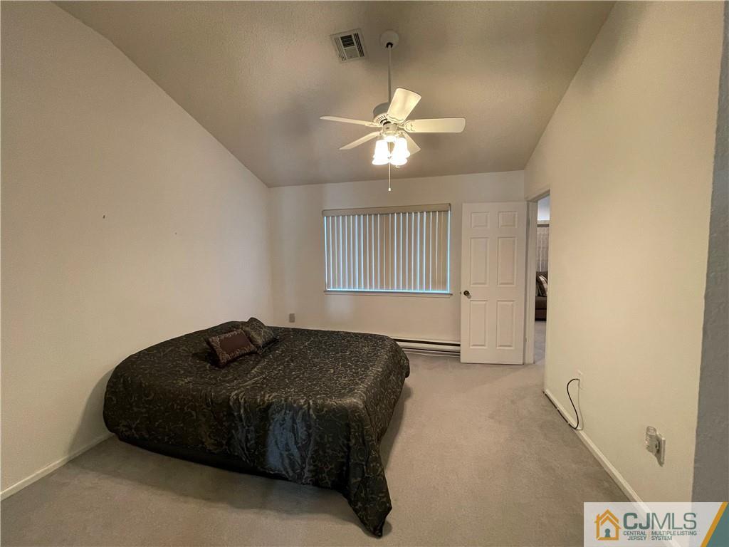 656 Nutley Drive, Unit A Monroe Township, NJ 08831 - Photo 23 of 25 a bedroom with a bed and a chandelier