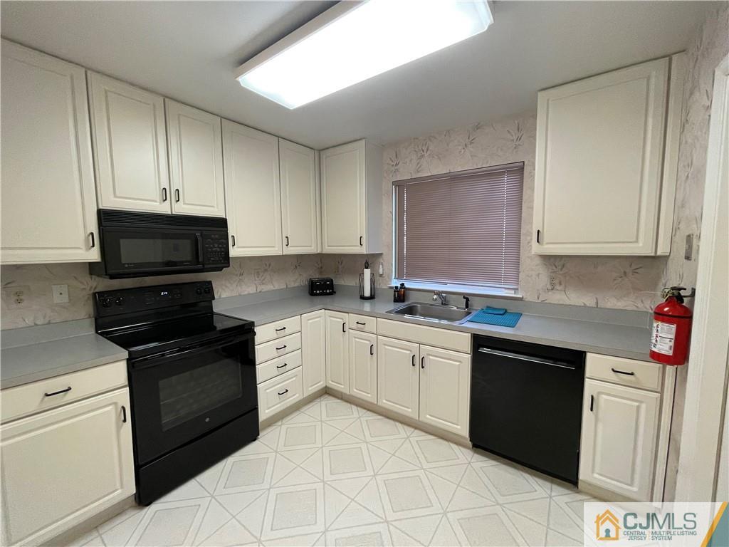 656 Nutley Drive, Unit A Monroe Township, NJ 08831 - Photo 9 of 25 a kitchen with granite countertop cabinets stainless steel appliances and a sink