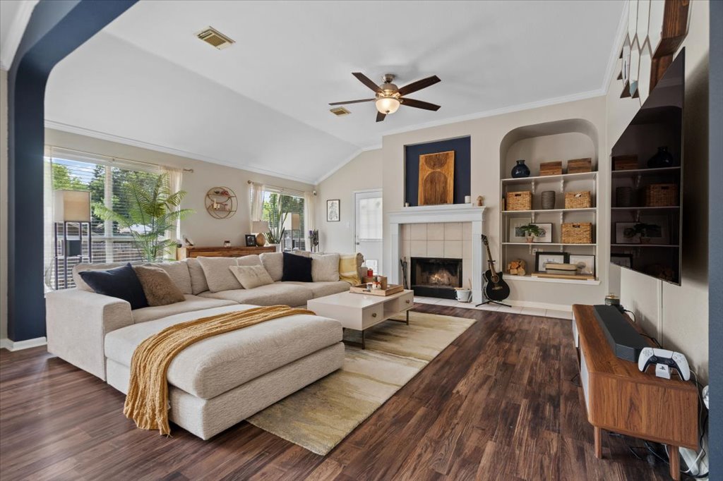 13200 Calf Roping Trail Austin, TX 78727 - Photo 13 of 28 Warm hardwood floors and a classic fireplace anchor this inviting living space under vaulted ceilings.