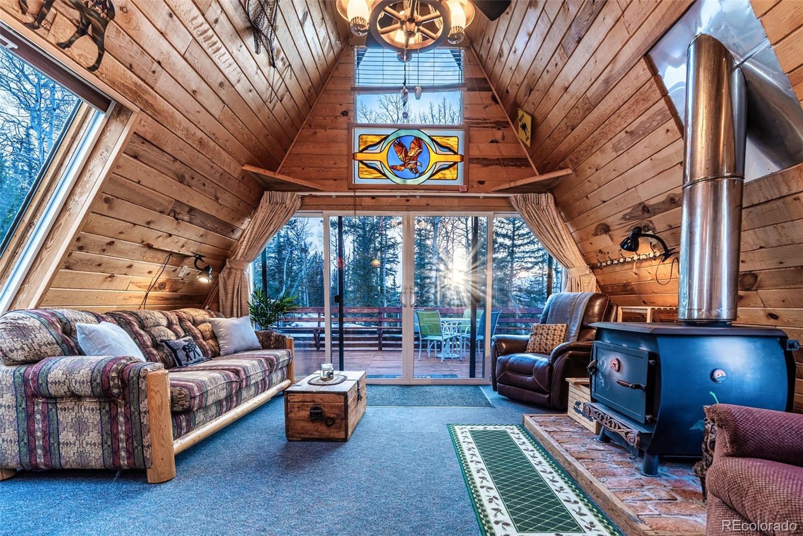 340 Wampum Lane Como, CO 80456 - Photo 2 of 35 a living room with furniture a fireplace and large windows