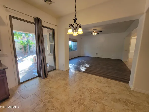 a view of a room with a chandelier fan and windows