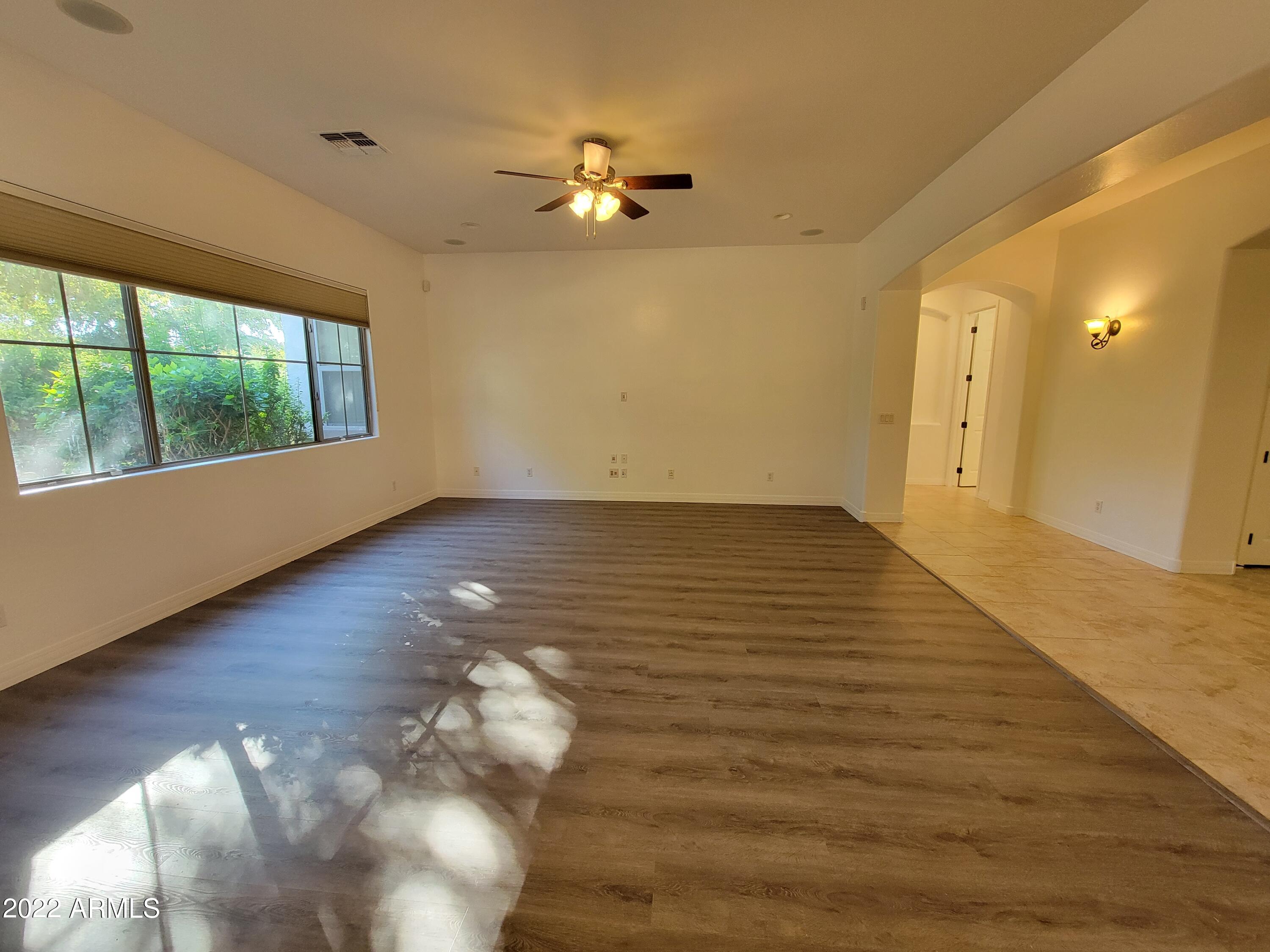 6335 South Roanoke Street Gilbert, AZ 85298 - Photo 14 of 36 a view of an empty room with wooden floor and a window
