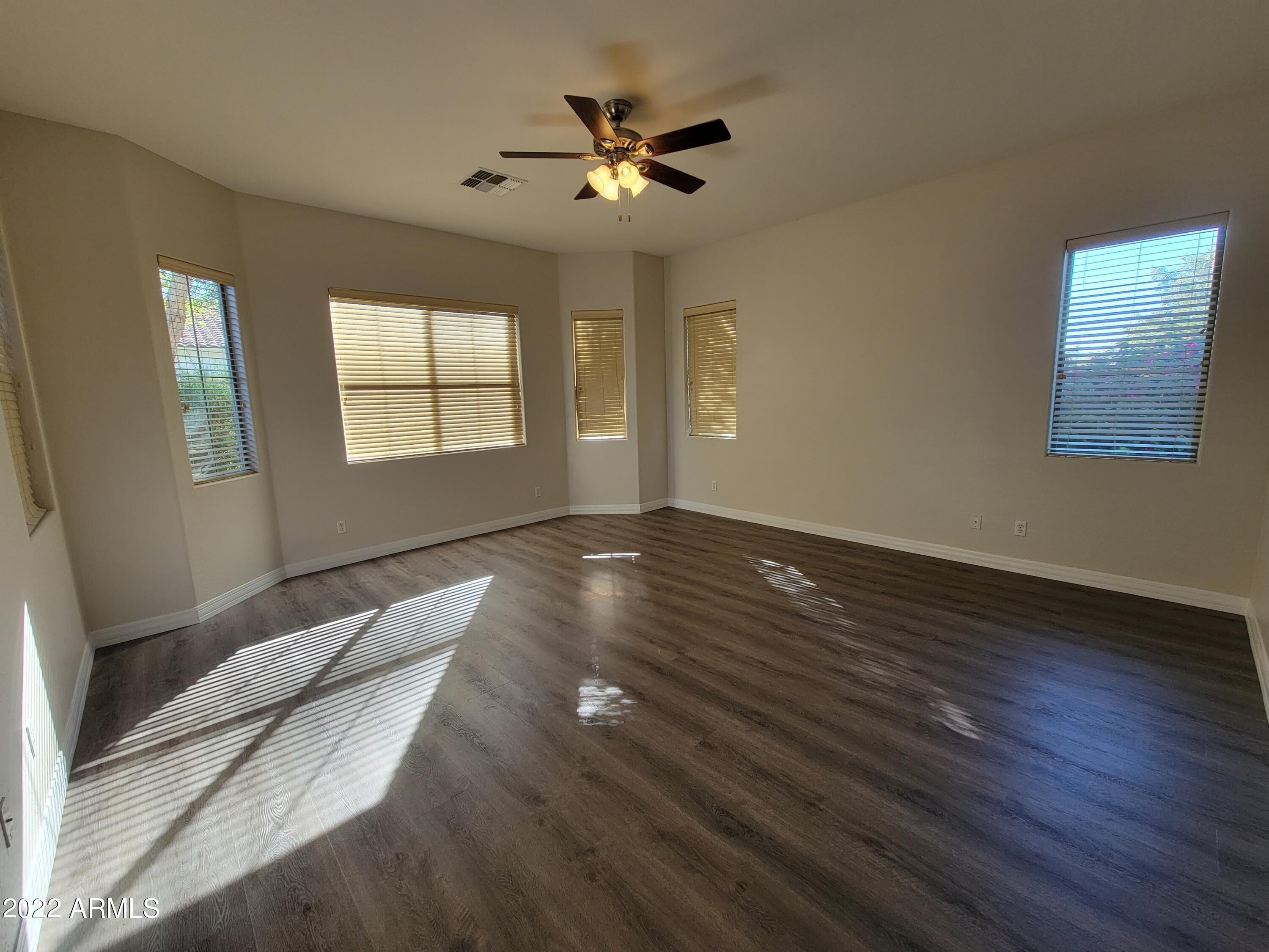 6335 South Roanoke Street Gilbert, AZ 85298 - Photo 15 of 36 a view of an empty room with wooden floor and a window
