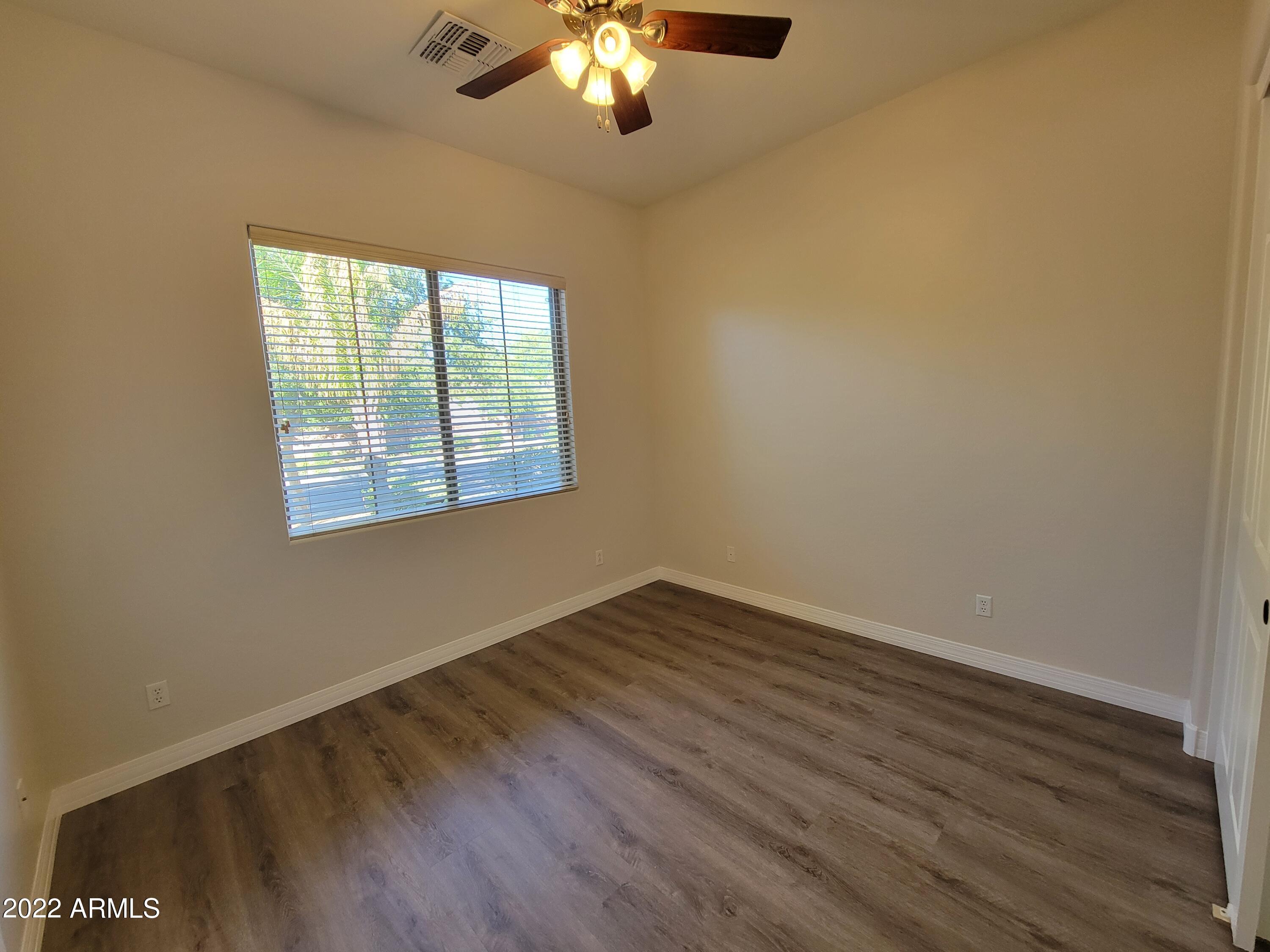 6335 South Roanoke Street Gilbert, AZ 85298 - Photo 22 of 36 a view of an empty room with wooden floor and a window