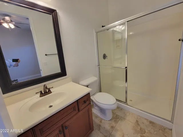 a bathroom with a sink vanity mirror and toilet