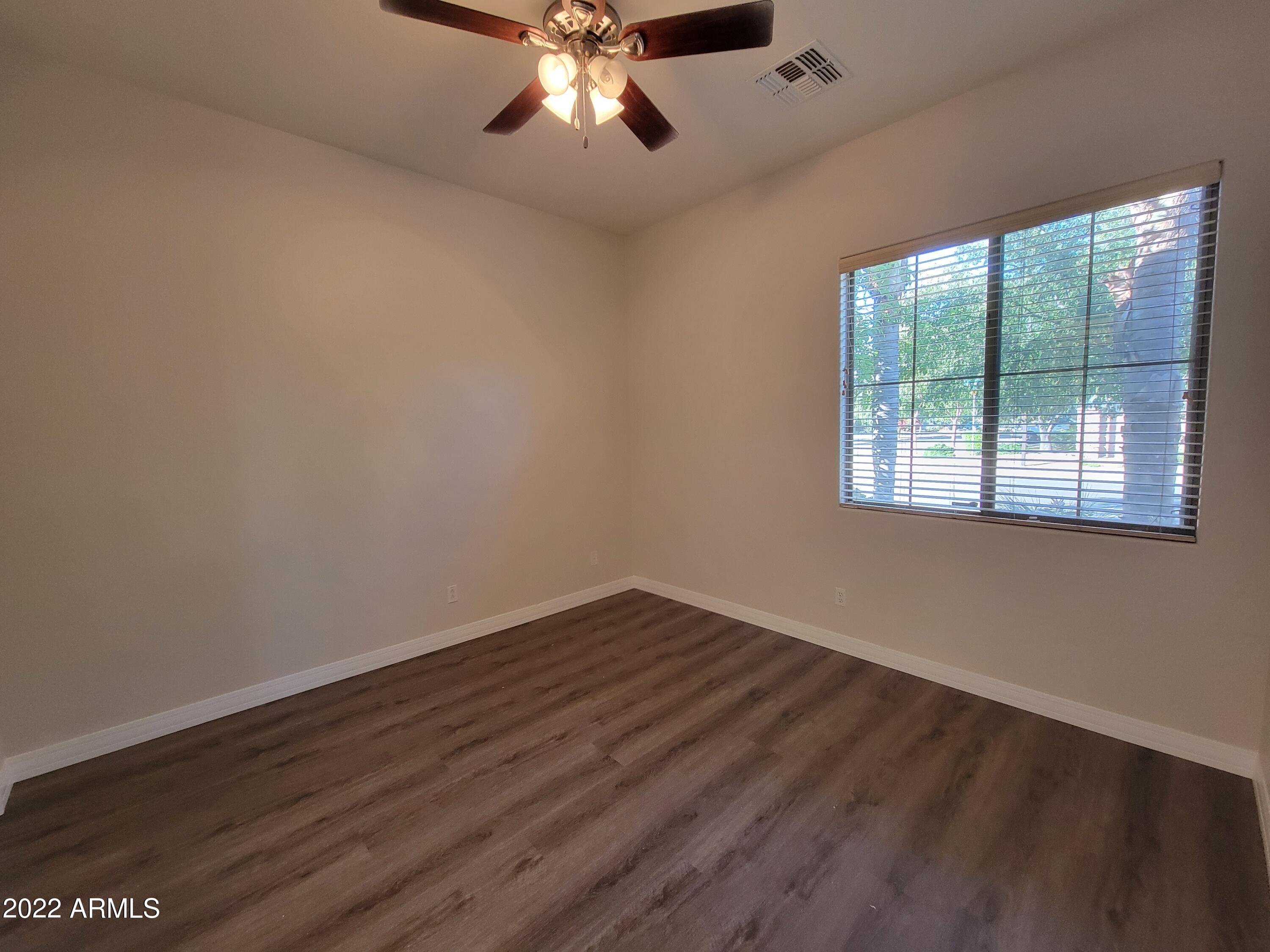 6335 South Roanoke Street Gilbert, AZ 85298 - Photo 25 of 36 a view of an empty room with wooden floor and a window
