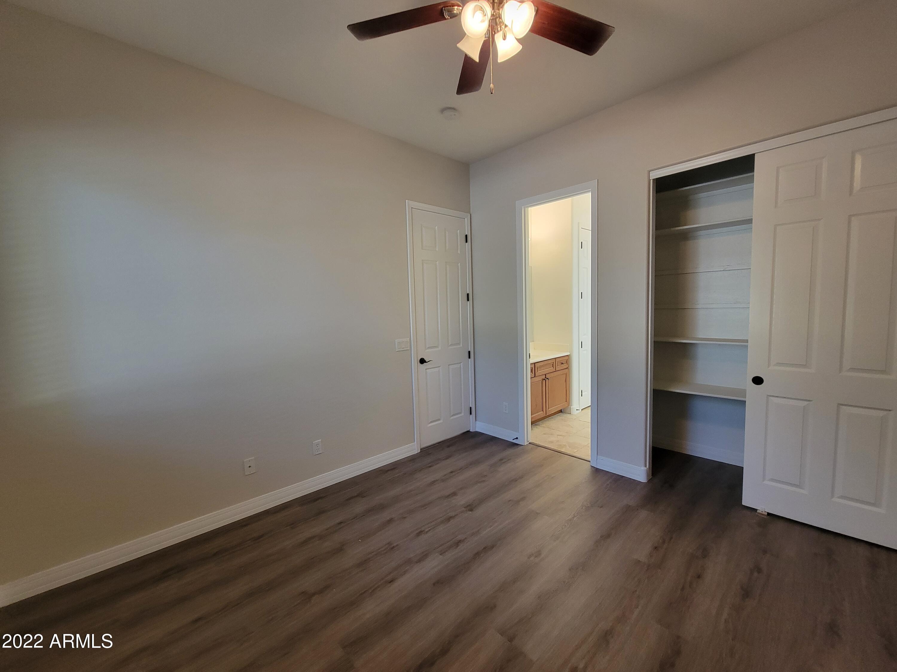 6335 South Roanoke Street Gilbert, AZ 85298 - Photo 26 of 36 an empty room with wooden floor chandelier and windows