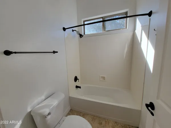 a bathroom with a shower a toilet and a tub