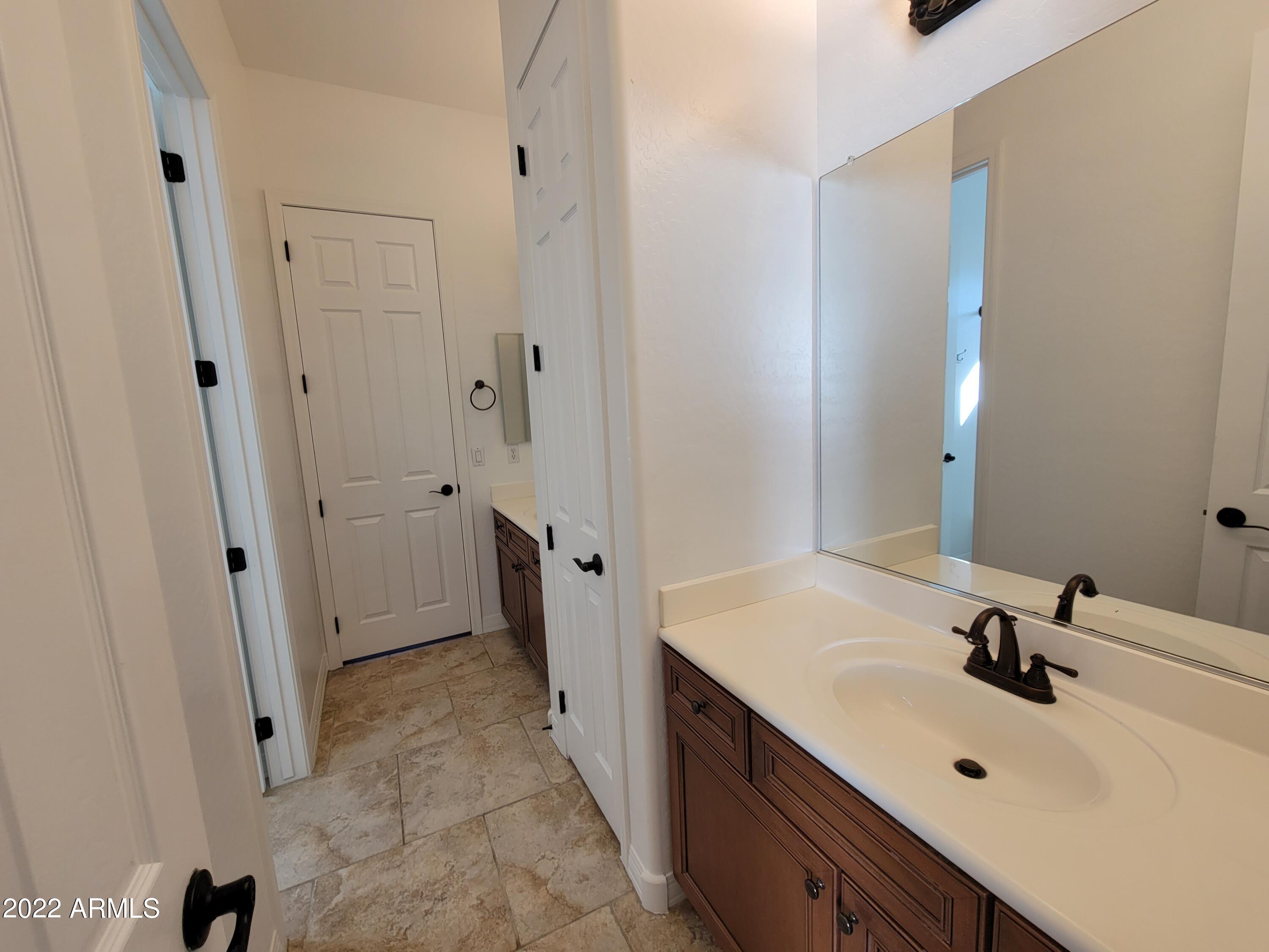 6335 South Roanoke Street Gilbert, AZ 85298 - Photo 29 of 36 a bathroom with a sink and mirror