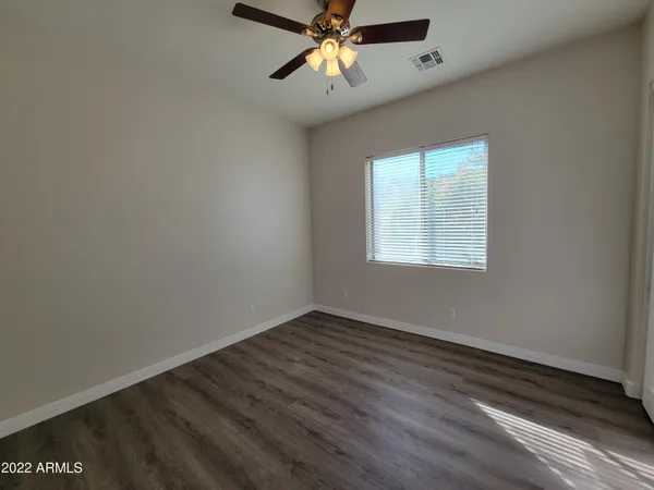 an empty room with a window and a ceiling fan