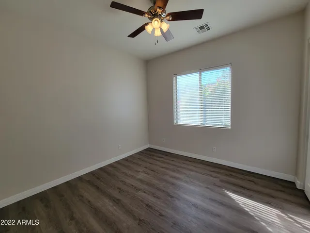 an empty room with a window and a ceiling fan