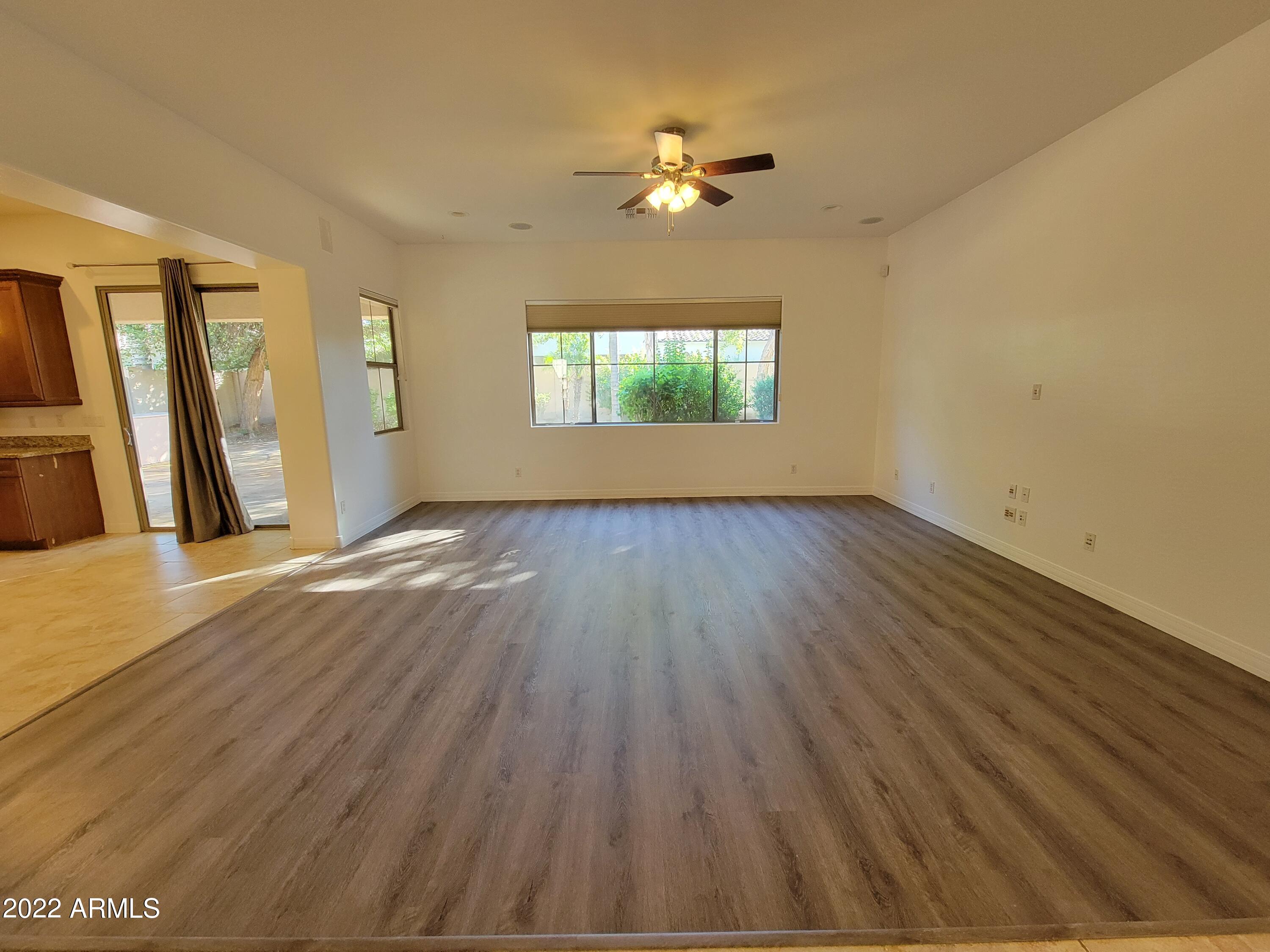 6335 South Roanoke Street Gilbert, AZ 85298 - Photo 6 of 36 a view of an empty room with wooden floor and a window
