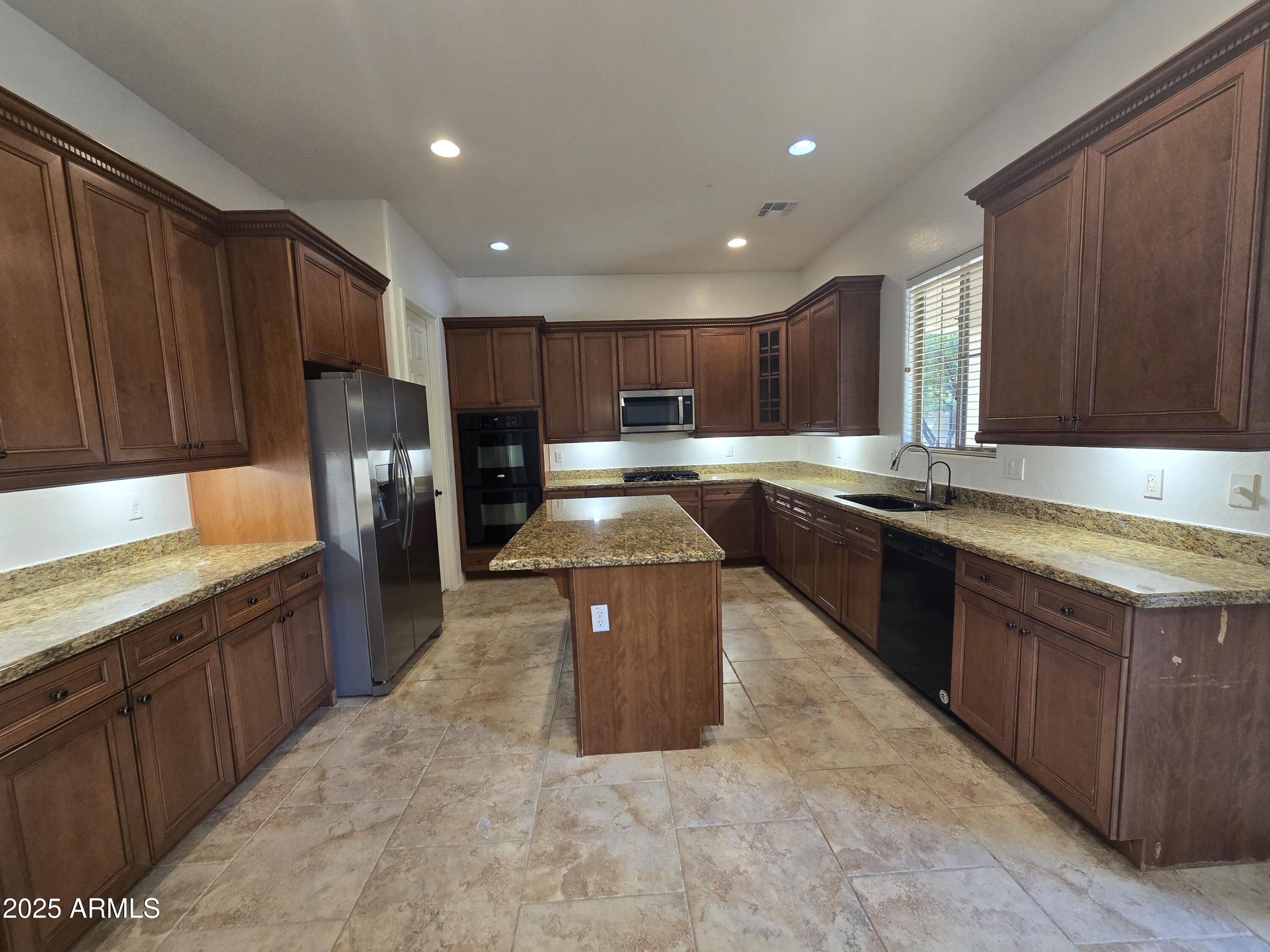 6335 South Roanoke Street Gilbert, AZ 85298 - Photo 8 of 36 a large kitchen with wooden cabinets a sink and dishwasher