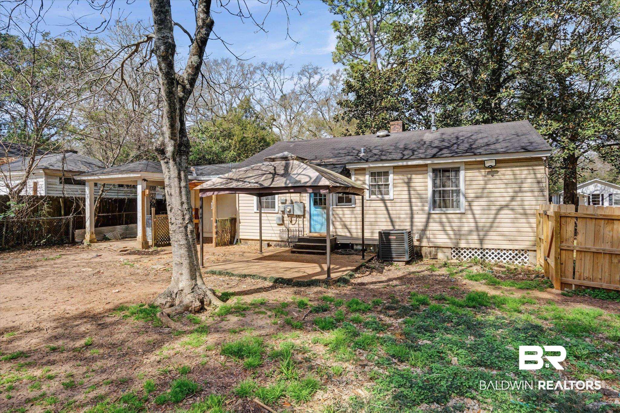 5117 Norton Lane Mobile, AL 36608 - Photo 23 of 35 Rear view of house with a fenced backyard, a patio area, and a chimney