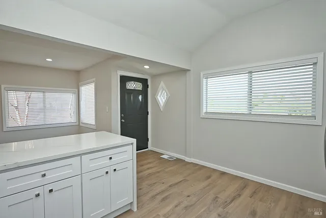a kitchen with white cabinets and a stove top oven