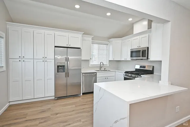 a kitchen with cabinets stainless steel appliances and a counter space
