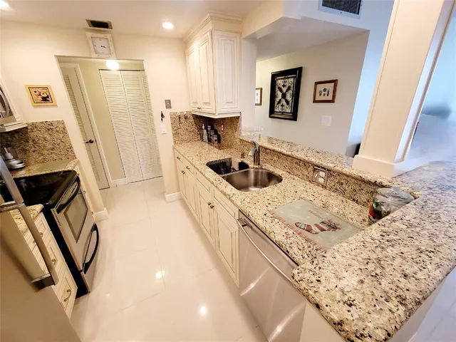 a kitchen with a sink a refrigerator and a stove