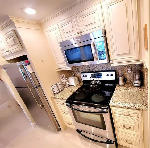 a kitchen with stainless steel appliances granite countertop a stove and a microwave